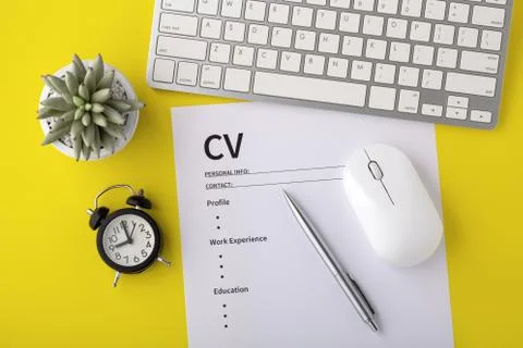 CV with clock, computer keyboard, pen on yellow background, top view Stock Photos