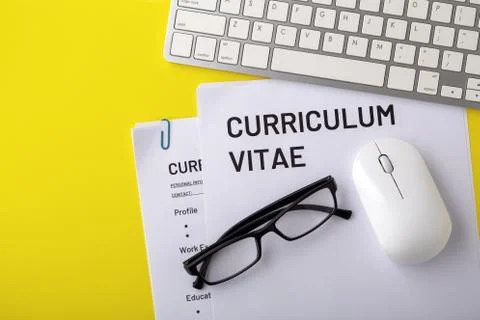 CV, curriculum vitae with computer keyboard on yellow background, top view Stock Photos