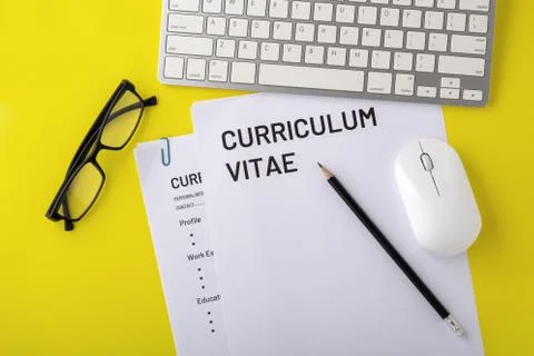 CV, curriculum vitae with computer keyboard, mouse, pencil on yellow desk, to Stock Photos