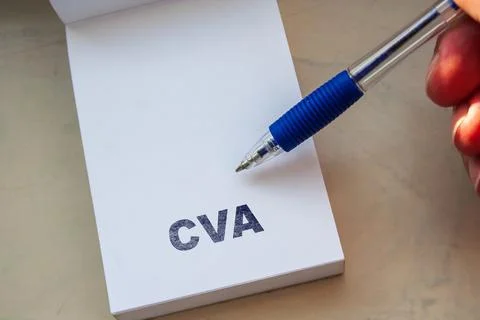 CVA written on white notepad page held by hand with blue ballpoint pen, concept Stock Photos
