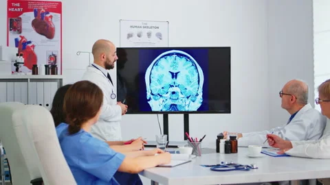 Cvalified bearded head doctor explaining brain structure using monitor Stock Footage 144615901