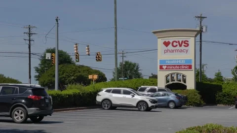 CVS Pharmacy store exterior with a bold red logo, large red awning and park.. 库存影片 335224060