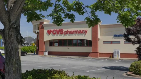 CVS Pharmacy store exterior with a bold red logo, large red awning and park.. 库存影片 335224253