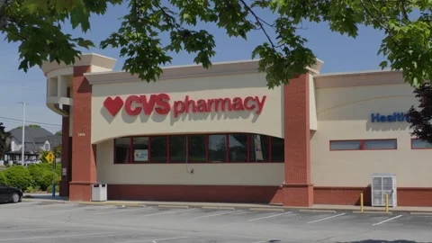 CVS Pharmacy store exterior with a bold red logo, large red awning and park.. Stock Footage 340575783