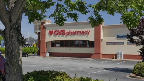 CVS Pharmacy store exterior with a bold red logo, large red awning and park.. Stock Footage 340575798