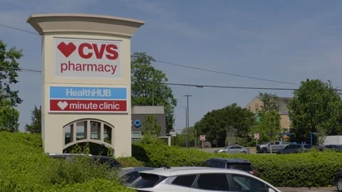 CVS Pharmacy store exterior with a bold red logo, large red awning and park.. Stock Footage 340575837