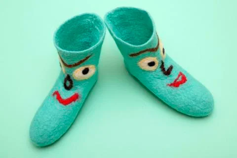 Cyan felt socks with a pattern on a turquoise background Stock Photos