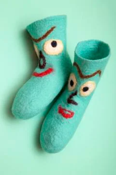 Cyan felt socks with a pattern on a turquoise background Stock Photos