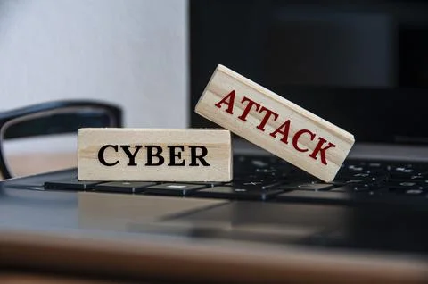 Cyber attack text on wooden blocks on top of a laptop. Stock Photos