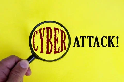 Cyber attack text on yellow cover with hand holding magnifying glass. Inter.. Stock Photos