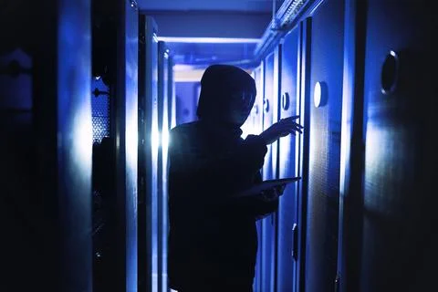 Cyber attacks can really sneak up on you. a hacker using a digital tablet in a Stock Photos