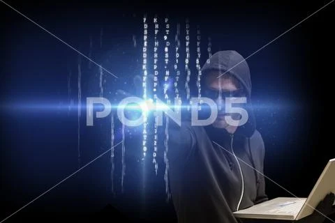 Cyber criminal is holding a laptop against matrix code rain background Stock Photos
