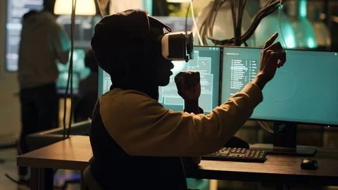 Cyber criminal using virtual reality haeadset to hack computer firewall Stock Photos