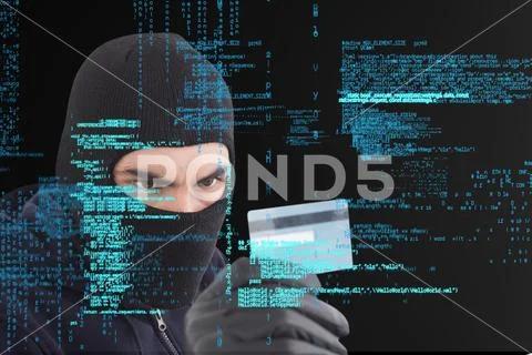 Cyber criminal wearing a hood is holding a credit card against matrix digital Stock Photos