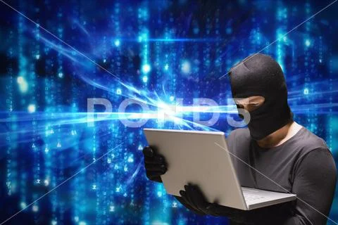 Cyber criminal wearing hood using a laptop against blue abstract background Stock Photos