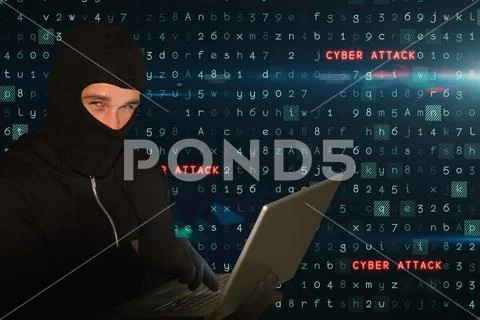 Cyber criminal wearing a hoot is hacking on laptop against matrix code rain Stock Photos