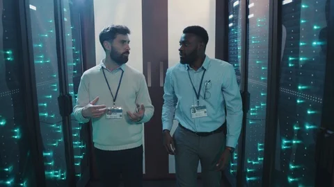 In cyber data center two diverse server engineers talking about work walking Stock Footage 119081356