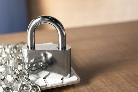 Cyber security. Keyboard with padlock and chain on wooden table, closeup. S.. 写真素材