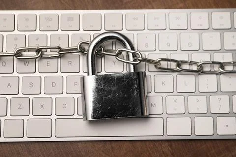 Cyber security. Keyboard with padlock and chain on wooden table, top view 写真素材
