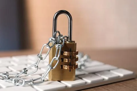 Cyber security. Keyboard with padlock and chain on wooden table, closeup 写真素材