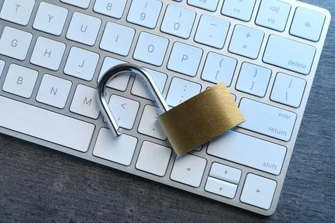 Cyber security. Open padlock and keyboard on dark grey table, top view Stock Photos