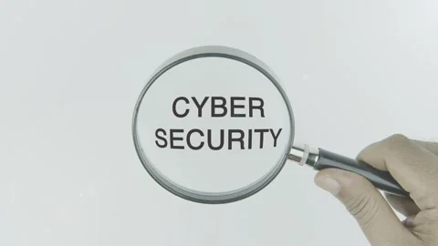 Cyber Security text or word highlighted by a magnifying glass in a hand Stock Footage 303608702