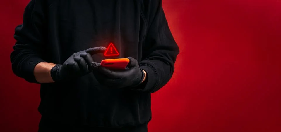 Cybercrime featuring hacker using smartphone with digital warning symbol. O.. Stock Photos
