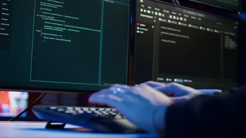 Cybercriminal breaching security systems while hiding in secret HQ, close up Stockfoto's