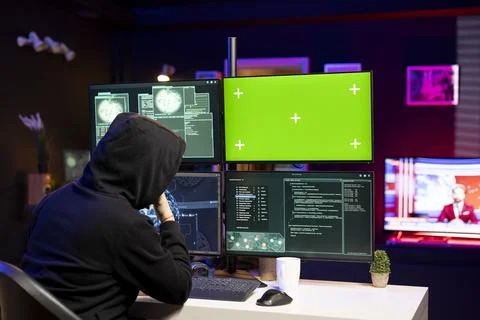 Cybercriminal coding on green screen PC, creating stealth malware Stock Photos