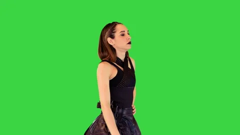 Cyberpunk girl in leather skirt and with gun on belt walks on a Green Screen Stock Footage