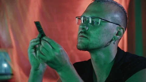 Cyberpunk programmer hacker analyzing a futuristic computer microchip Stock Footage 341659599