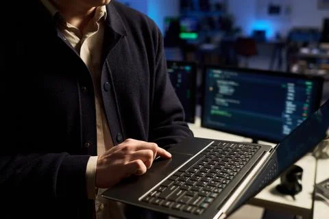 Cybersecurity Analyst Coding on Laptop in Modern Office at Night Stock Photos