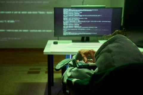 Cybersecurity Analyst Engaged in Writing Code Within a Dimly Lit Environment for Stockfoto's
