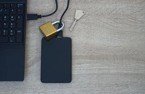 Cybersecurity concept - Physical lock on external SSD data storage. Stock Photos