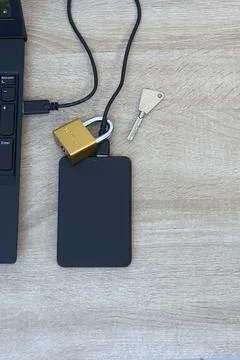 Cybersecurity concept - Physical lock on external SSD data storage. Stock Photos