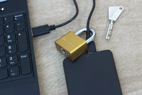 Cybersecurity concept - Physical lock on external SSD data storage. Stock Photos