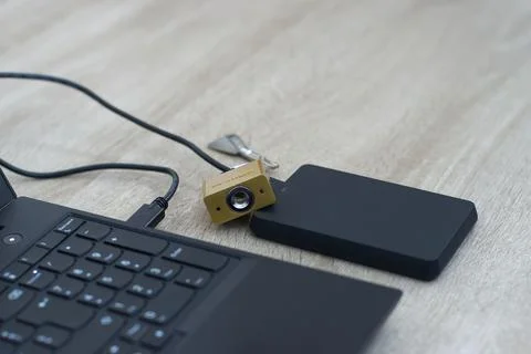 Cybersecurity concept - Physical lock on external SSD data storage. Stock Photos