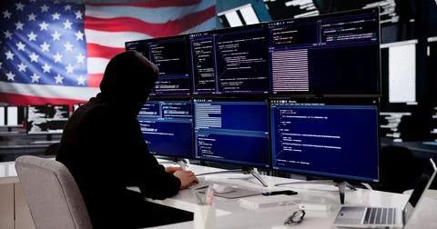 Cybersecurity Expert Coding Against American Flag Backdrop 스톡 사진