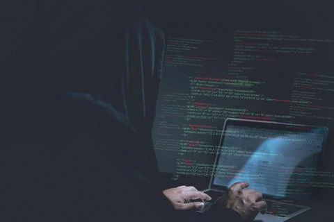 Cybersecurity hacker typing code on laptop in dark room, concept of hacking.. Stock Photos