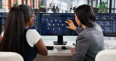 Cybersecurity Manager Coaches Diverse Team Using Advanced Software Tools. Stock Photos