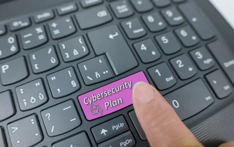 Cybersecurity plan key on a gray keyboard. Finger pressing key Stock Photos