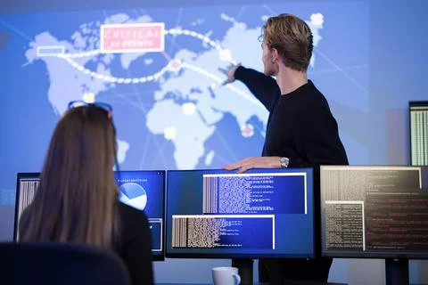 Cybersecurity professionals collaborating on real-time threat monitoring and Stock Photos