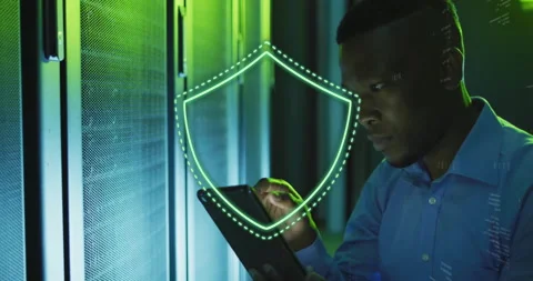 Cybersecurity shield animation over man using tablet in server room Stock Footage 304767422