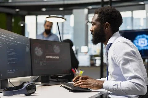Cybersecurity specialist blocking network intrusion inside office Stock-Fotos