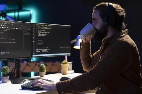 Cybersecurity specialist drinking coffee while fixing vulnerabilities 스톡 사진