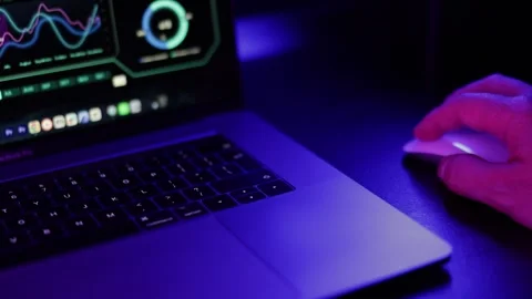 Cybersecurity Specialist Working on Laptop with Code and Analytics in Dark Neon Stock Footage 336581989