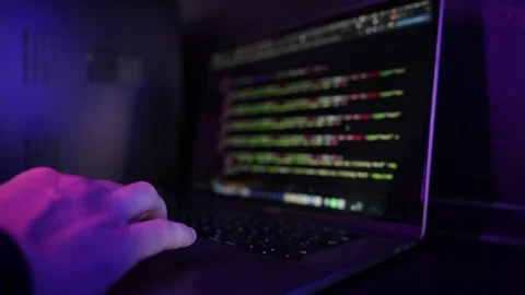 Cybersecurity Specialist Working on Laptop with Code and Analytics in Dark Neon Stock Footage 336582154