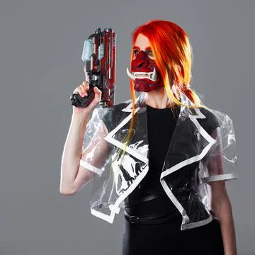 Cyborg mercenary in Asian demon mask, young woman with bright orange hair Stock Photos