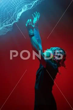 Cyborg raised his hands and looks at the light pouring from above. Biological Stock Photos