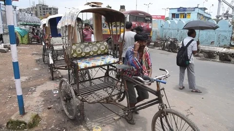 Cycle rickshaw driver outside Howrah Junction railway station Vídeos de archivo 77446257